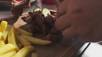 The chef serves meat, potatoes, herbs, tomatoes and vegetables on the board video