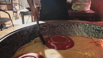 Chef removing plates from steaming rice in a large pilaf cauldron video