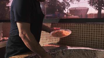 The chef puts carrots with a slotted spoon in a plate with rice from a large cauldron for pilaf video