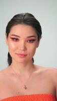 Vertical portrait of a young model with long black hair and bright makeup video