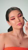 Dubai, UAE - 7 10 2023. The master makes professional makeup for a young woman with long black hair video