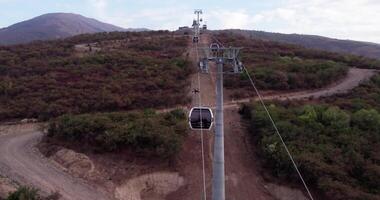 un' fuco mosche al di sopra di il cabine di un' cavo auto nel il montagne su un' nuvoloso autunno giorno video