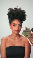 professionnel maquillage Maître s'applique peindre à une Jeune modèle avec frisé cheveux video