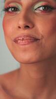 Vertikale Porträt von ein jung Modell- mit trostlos afro Haar und hell bilden. Farben Würfel mit Lippenstift. video