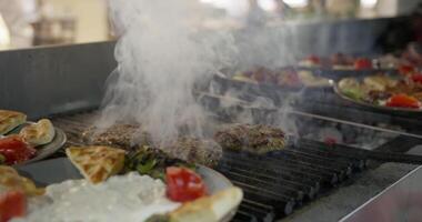 Frying cutlets in the hotel kitchen next to a served plate of food. video