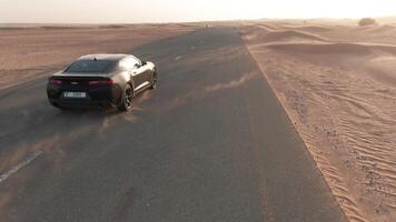 un zumbido detrás un coche conducción a lo largo un Desierto la carretera video