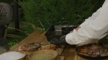 Table setting by a waiter in a night open cafe surrounded by trees and fir trees video