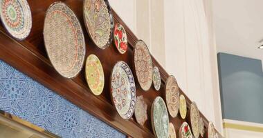 Tashkent, Uzbekistan - 8 4 2022. Ceramic plates with ornaments as an element of wall decor in the hotel lobby video