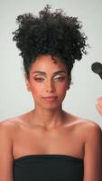 professionnel maquillage Maître s'applique peindre à une Jeune modèle avec frisé cheveux video