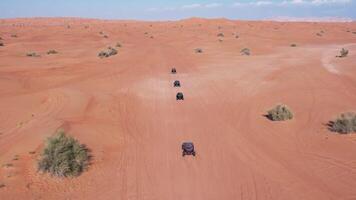 un zumbido moscas terminado un caravana de buggies conducción mediante el Desierto arena video