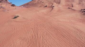 A drone flies over a buggy driving through the sand dunes of the desert video