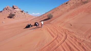 Drone view of people riding on a board on the sand dunes of the desert video