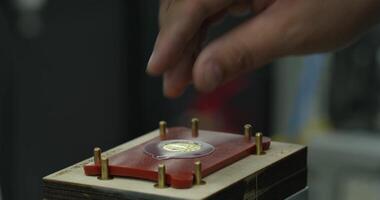 le mains de le ouvrier installer le partie sur le presse à le usine video