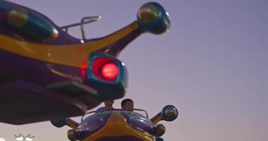 Tashkent, Uzbekistan - 8 4 2022. Children ride a carousel in the form of a rocket in an amusement park video