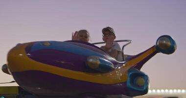 Tashkent, Uzbekistan - 8 4 2022. Children ride a carousel in the form of a rocket in an amusement park video