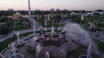 A drone flies over a fountain in an amusement park video