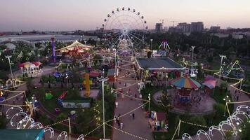 Tashkent, Uzbekistan - 8 4 2022. A drone flies over an amusement park with carousels and a Ferris wheel video