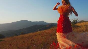 Drone flies over young woman in autumn outfit on meadow in mountains on sunset background video