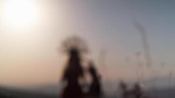 Tashkent, Uzbekistan - 1 9 2020. Film crew with a young female model in an autumn designer dress made of flowers and a headdress made of spikelets on the background of the sunset in the mountains. video