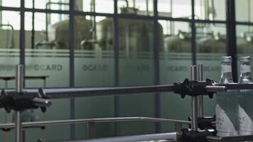 Tashkent, Uzbekistan - 8 4 2022. A man in a white coat checks water bottles on a conveyor belt video