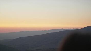 jung weiblich Modell- auf das Hintergrund von Sonnenuntergang im das Berge. video