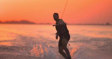 Wakesurfer rides a board on a lake video