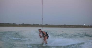 Wakesurfer rides a board on a lake video