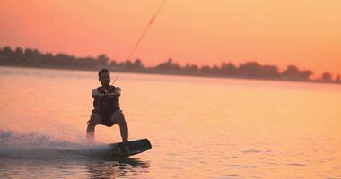 Wakesurfer rides a board on a lake video