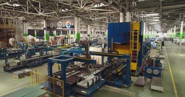 The drone flies in a large workshop on an automatic conveyor. video