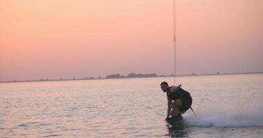 Wakesurfer rides a board on a lake video