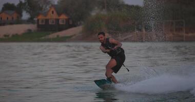 Wakesurfer rides a board on a lake video