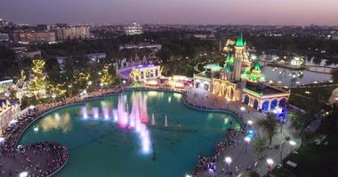 das Drohne fliegt Über das Schloss von ein Amüsement Park mit ein Singen Brunnen. video