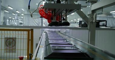 A robotic arm stacks computer monitors on a conveyor belt. A large workshop for the production of electronic components. video