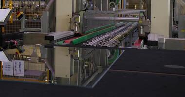 The operator works on the conveyor for glass processing. Large workshop video