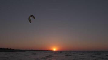 homme sur le kiteboard monte dans le soir video