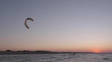 homme sur le kiteboard monte dans le soir video