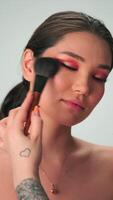 Dubái, uae - 7 7 10 2023. el Maestro hace profesional maquillaje para un joven mujer con largo negro pelo video