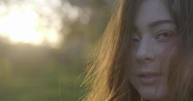 närbild av brun hared flicka med grå ögon spinning i de ljus av de miljö Sol video