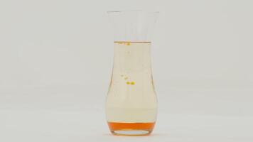 Orange lava lamp effect in a glass vase on white background, slow motion video