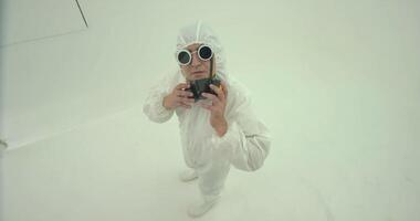 Man in white chemical protection suit takes off his glasses video