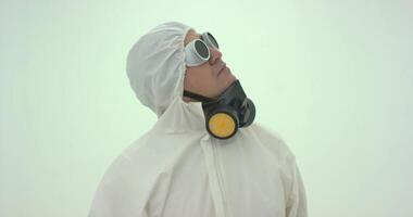 homme dans blanc chimique protection costume prend de le sien des lunettes video