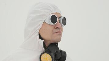 homme dans blanc chimique protection costume prend de le sien des lunettes video