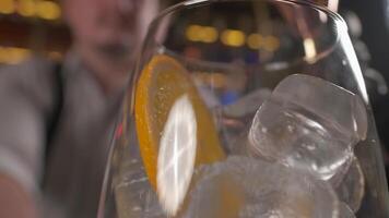 barmen bär svart handskar häller campari från shaker till de glas video