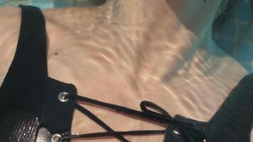 close-ups e detalhes do gotas de água em jovem mulher pele vestindo Preto roupa de banho video