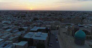 en Drönare flugor över de arkitektonisk komplex poi-kalon bland gammal hus i bukhara, uzbekistan. tidigt molnig morgon- video