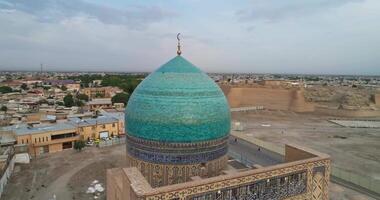 A drone flies over the architectural complex Poi-Kalon. On the background of a house in old Bukhara, Uzbekistan. Cloudy day video