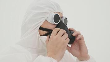 homme dans blanc chimique protection costume prend de le sien des lunettes video