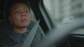 ung afrikansk kvinna körning bil på urban stad gata pendling video