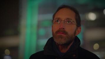 Young Man with Glasses Watching Light Show in the City at Night video