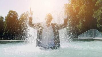 contento giovane uomo danza nel acqua Fontana nel estate tempo video